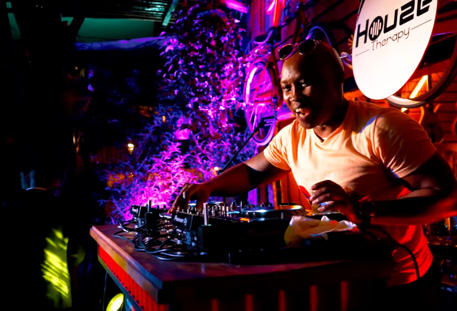 A DJ playing under purple lights